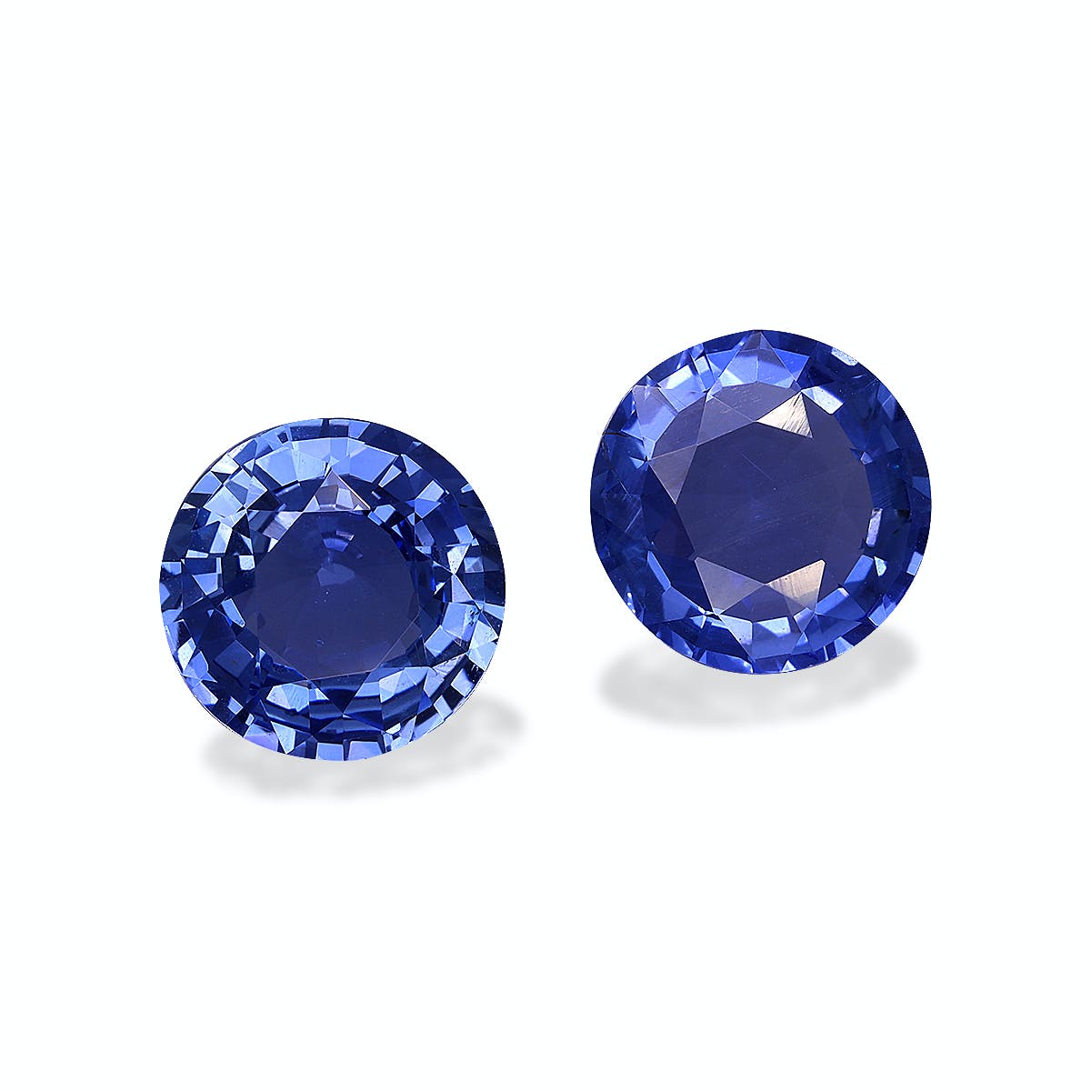 Le Saphir Bleu · 5,56ct de Bonnot Paris présente deux saphirs ronds d'un bleu profond aux facettes complexes serties sur un fond blanc uni, soulignant leur éclat et leur richesse.