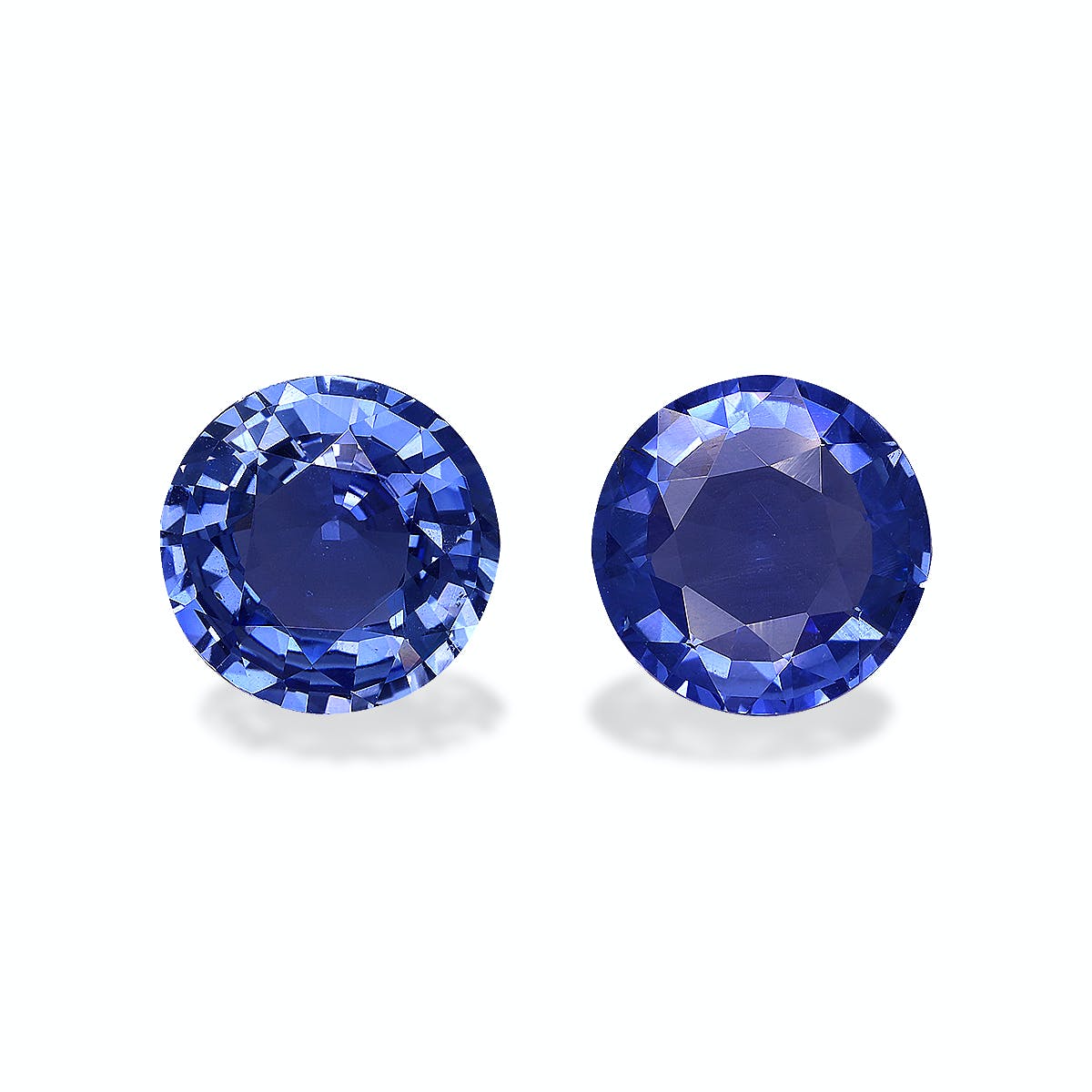 Deux Saphirs Bleus ronds et facettés de Bonnot Paris, totalisant 5,56 carats, se détachent côte à côte sur un fond uni. Sous la lumière, ils présentent des reflets brillants et des nuances de bleu profond.