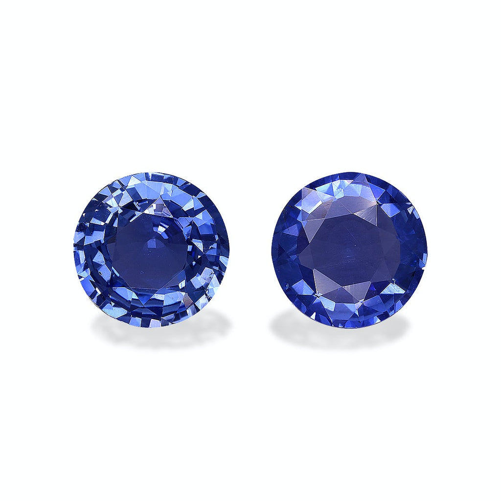 Deux Saphirs Bleus ronds et facettés de Bonnot Paris, totalisant 5,56 carats, se détachent côte à côte sur un fond uni. Sous la lumière, ils présentent des reflets brillants et des nuances de bleu profond.