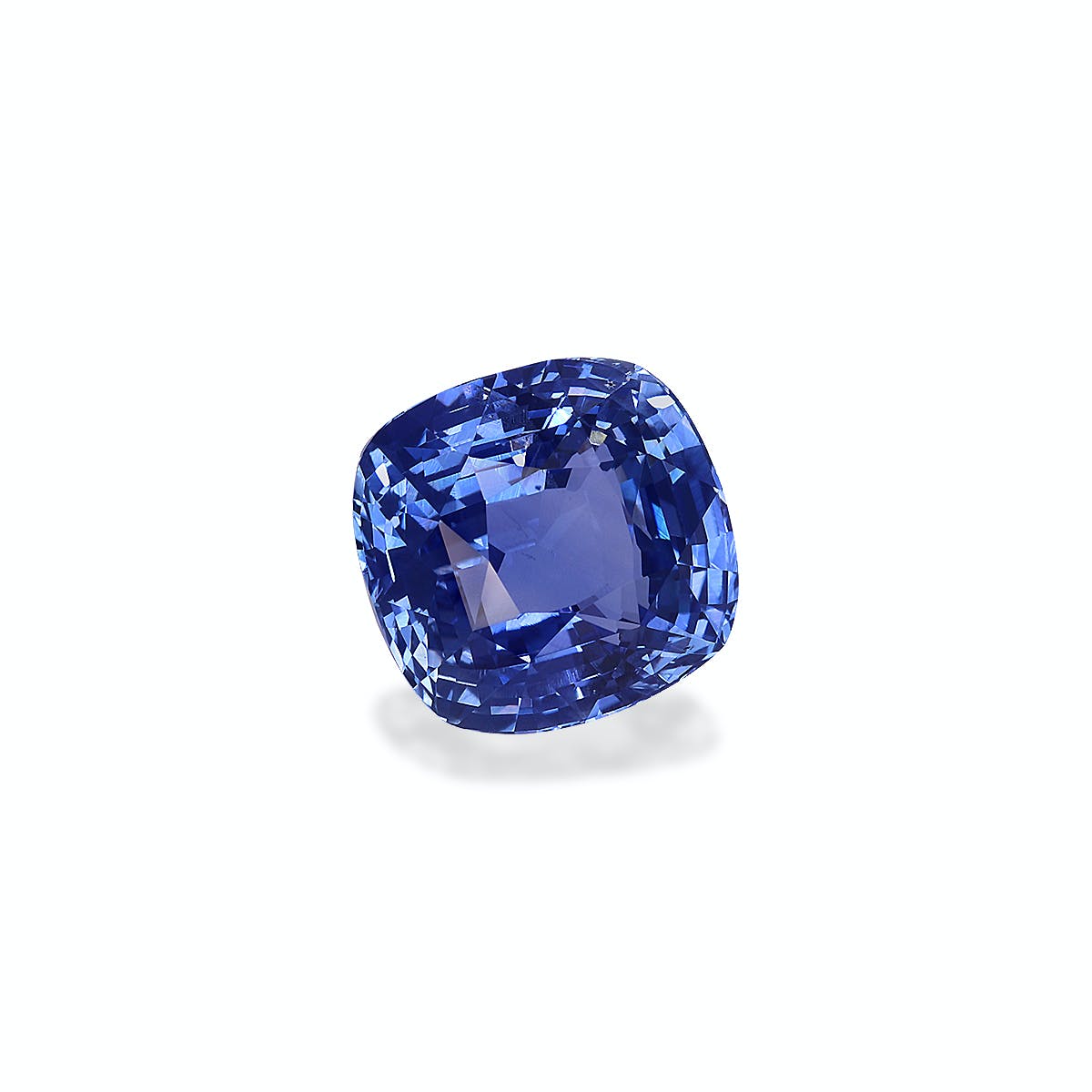 Le Saphir Bleu · 3,22 ct de Bonnot Paris est un saphir bleu vibrant, taille coussin, avec une surface facettée qui reflète la lumière et scintille sur un fond blanc uni.