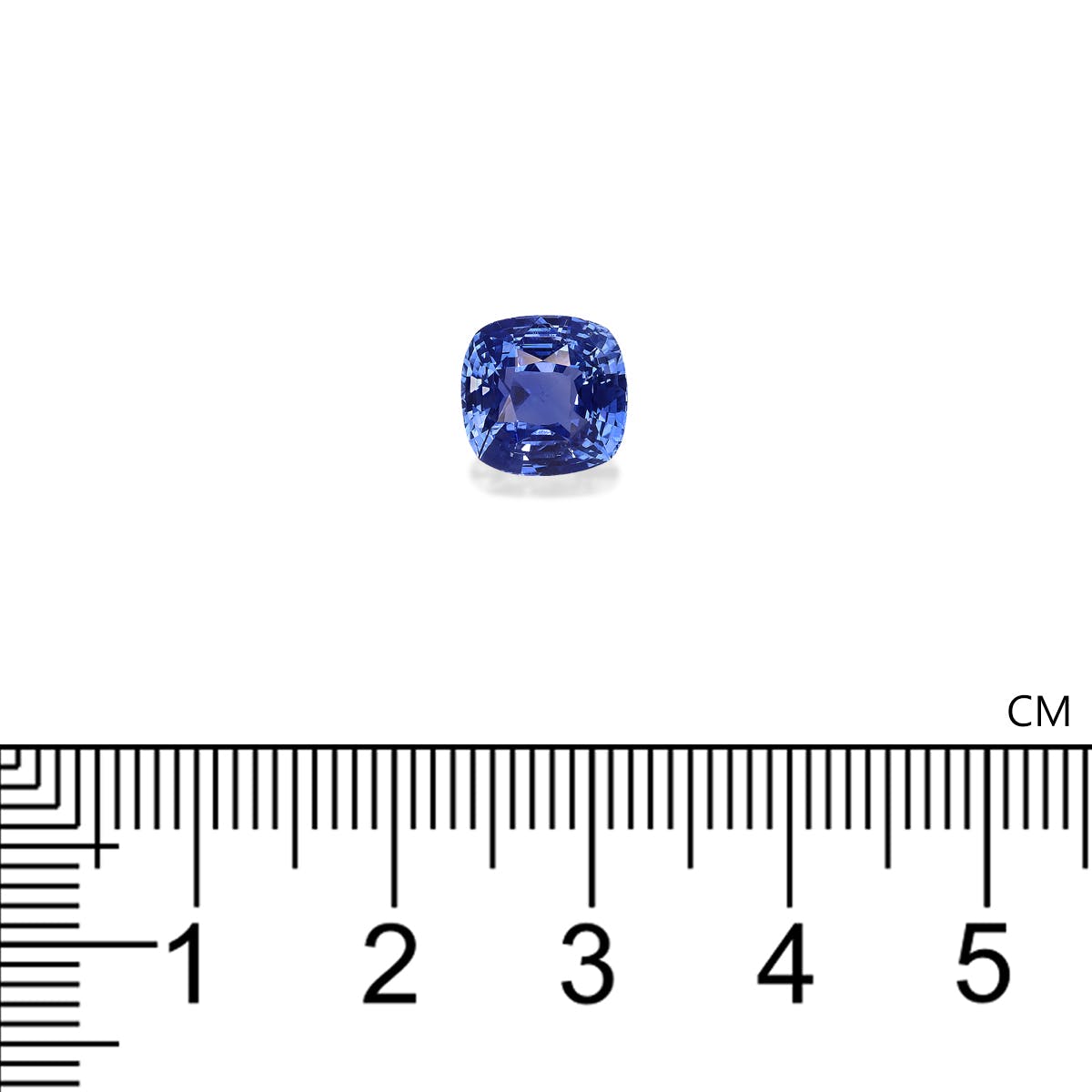 Le Saphir Bleu · 3,22 ct de Bonnot Paris est posé sur un fond blanc au-dessus d'une règle graduée en centimètres pour l'échelle, mettant en valeur sa couleur bleue vibrante et ses facettes symétriques.