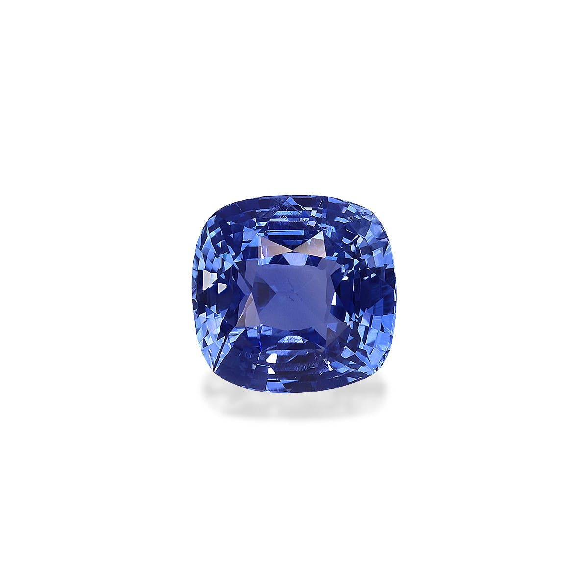 Un saphir bleu taille coussin de Bonnot Paris (Saphir Bleu · 3,22 ct) serti sur un fond blanc, présentant des facettes qui reflètent la lumière pour créer un jeu époustouflant de nuances de bleu diverses.