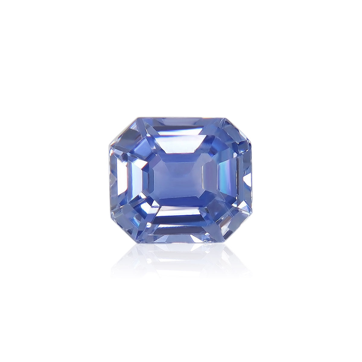 Le Saphir Bleu · 1,63ct de Bonnot Paris est une pierre précieuse bleue facettée de forme octogonale, présentant une surface vibrante et réfléchissante sur un fond blanc.