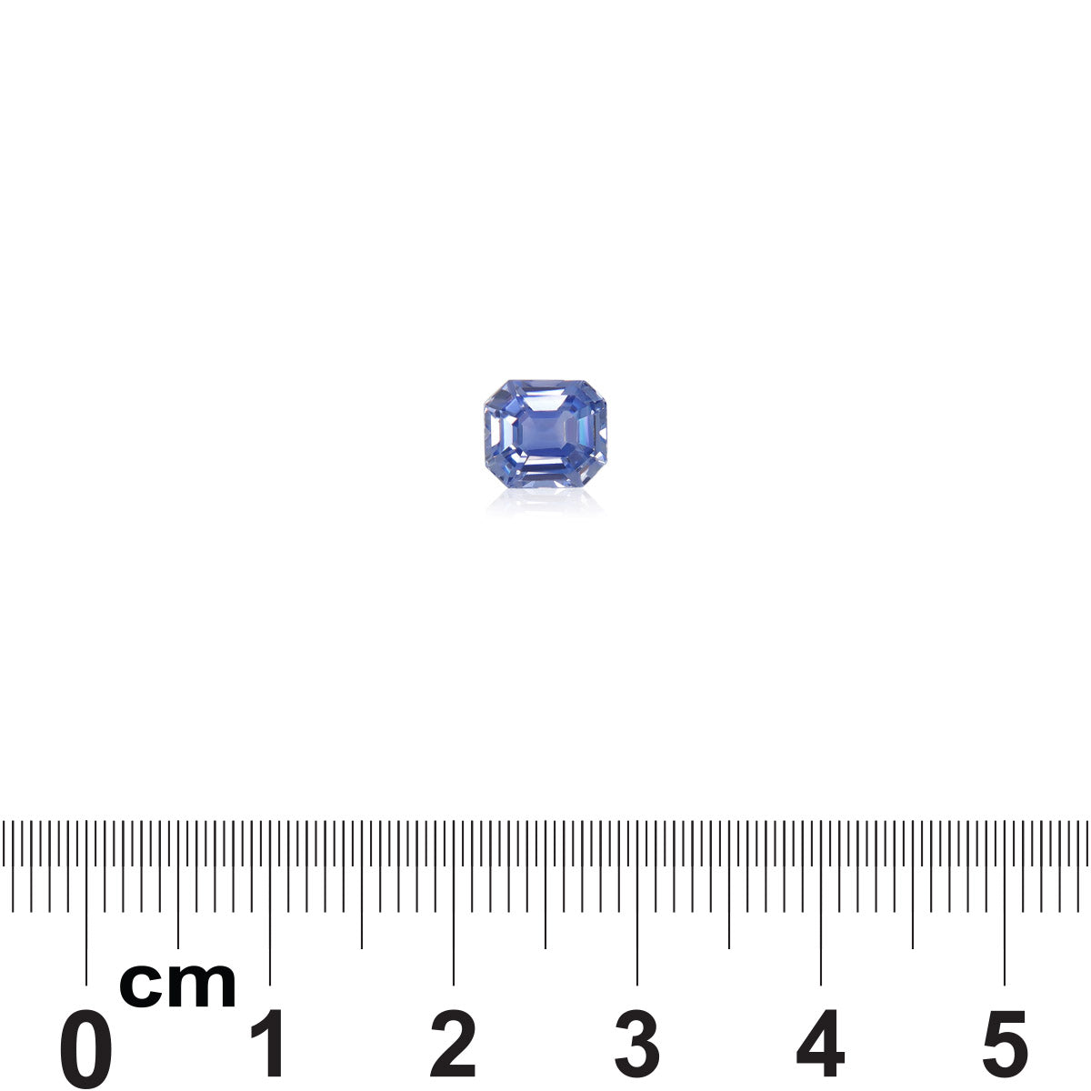 Le Saphir Bleu · 1,63ct de Bonnot Paris, une petite pierre précieuse octogonale bleue, est sertie sur un fond blanc avec une règle indiquant qu'elle mesure un peu plus d'un centimètre de large.