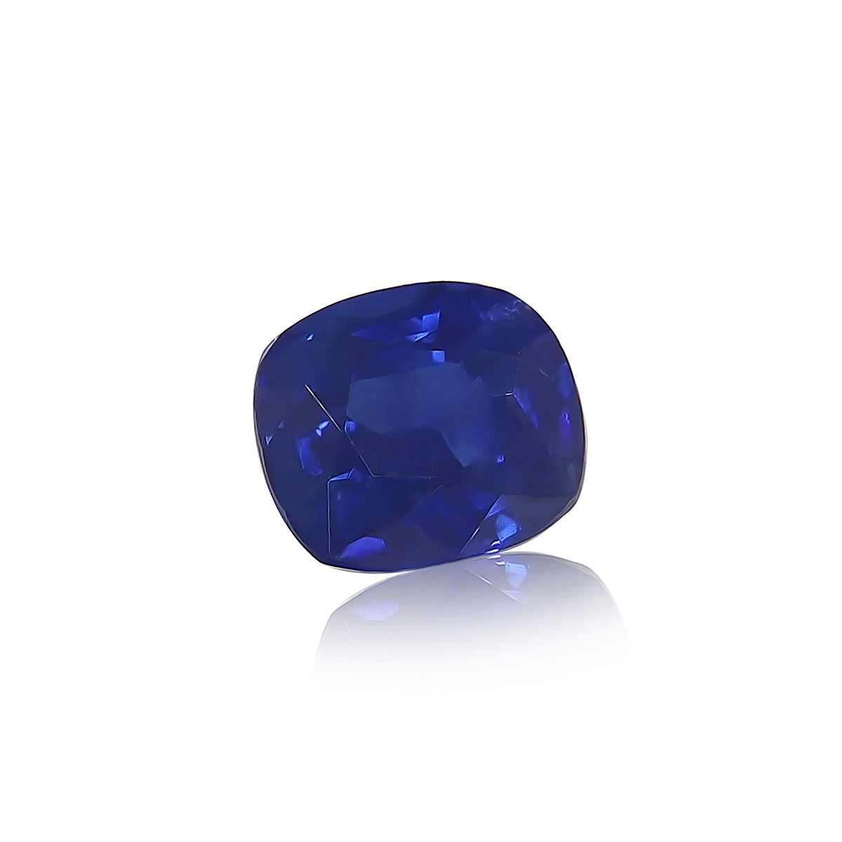 Un Saphir Bleu de 1,2 carat de Bonnot Paris, doté d'une pierre taille coussin d'un bleu profond avec des facettes réfléchissant la lumière, sertie sur un fond blanc uni.