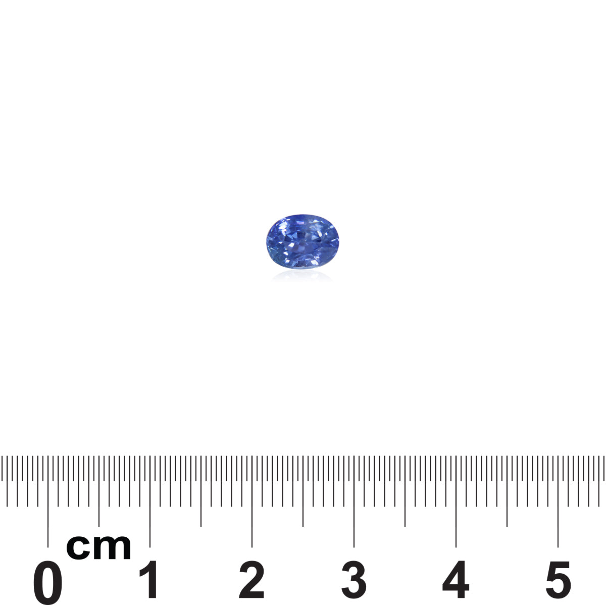 Le Saphir Bleu · 1,28 ct de Bonnot Paris, une pierre précieuse bleue de taille ovale, est placé sur une règle métrique affichant des centimètres et des millimètres, soulignant sa taille inférieure à 1 cm de longueur, avec une faible ombre projetée.