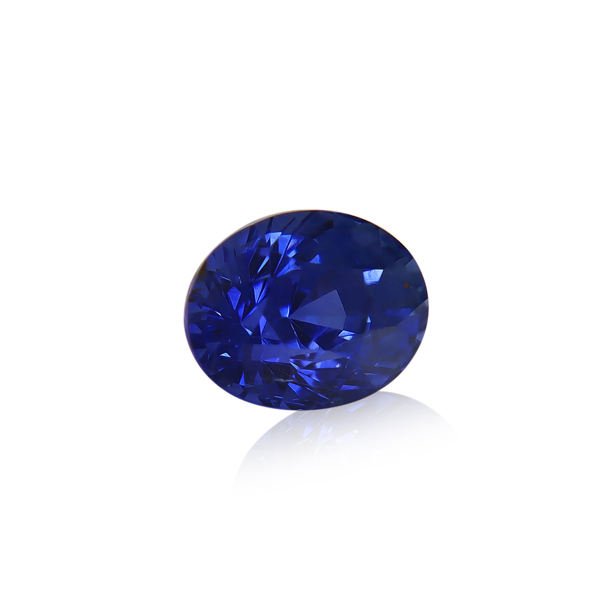 Le Saphir Bleu · 2,12 ct de Bonnot Paris est présenté en gros plan, mettant en valeur sa pierre précieuse ronde d'un bleu profond aux multiples facettes reflétant des nuances de bleu et de blanc sur une surface brillante sur un fond blanc uni.