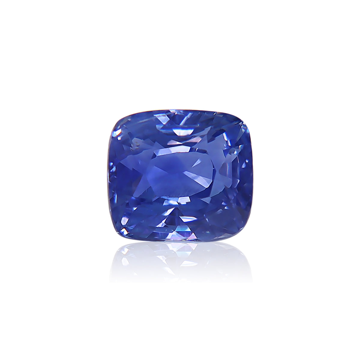 Le Saphir Bleu · 3,03 ct de Bonnot Paris est une pierre précieuse saphir bleu taille coussin avec une brillance éclatante et une surface multifacette reflétant la lumière, reposant sur un fond blanc pour mettre en valeur sa couleur bleu profond et sa clarté.
