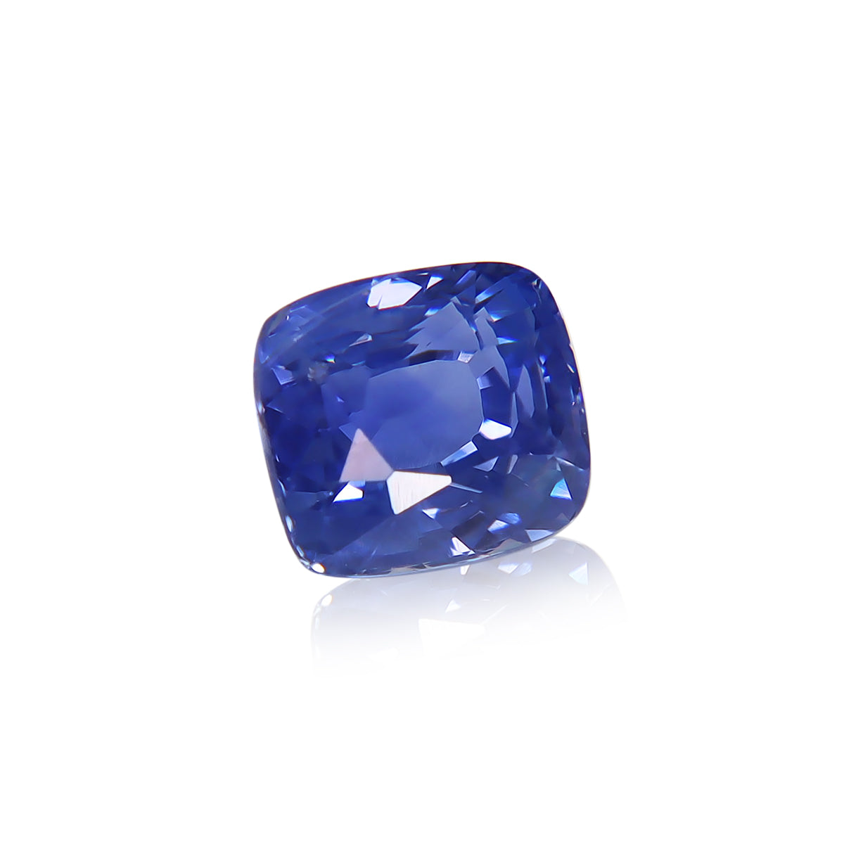 Un gros plan du Bonnot Paris « Saphir Bleu · 3,03 ct » met en valeur sa teinte bleu vif et profond avec une taille coussin qui reflète des reflets brillants sur un fond blanc uni.