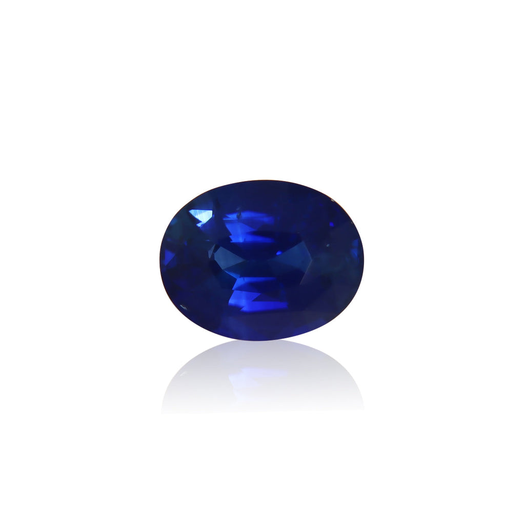 Le Saphir Bleu · 4,05ct de Bonnot Paris est un saphir bleu de forme ovale avec des surfaces facettées qui reflètent magnifiquement la lumière sur un fond blanc.