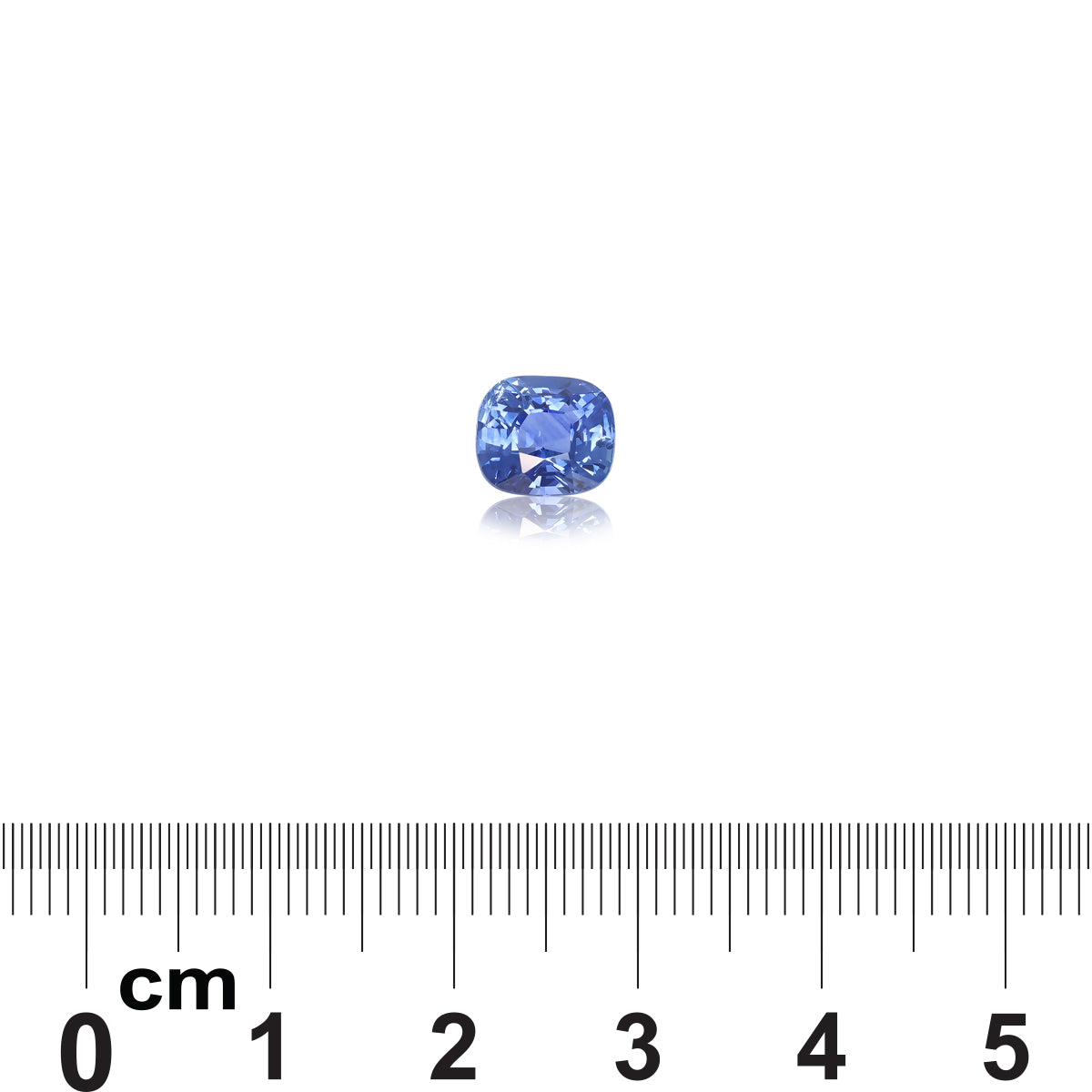 La pierre précieuse Saphir Bleu de 2,02 carats de Bonnot Paris est sertie sur un fond blanc, réfléchissant la lumière à sa base. En dessous, une règle graduée en centimètres de 0 à 5 indique sa taille.