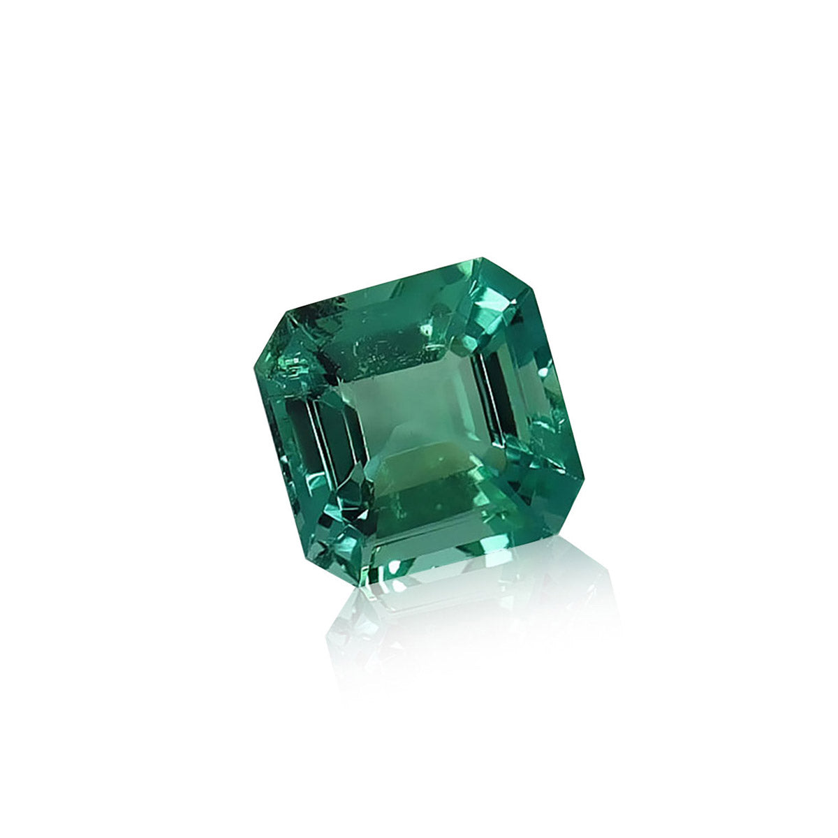 L'Émeraude de Zambie de Bonnot Paris est une pierre précieuse verte de 1,57 carat, taille carrée, aux bords biseautés et aux facettes réfléchissantes, inclinée sur un fond blanc avec une ombre douce.
