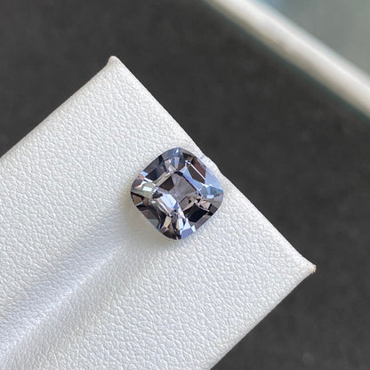 Le Spinelle Gris · 3,31 carats de Bonnot Paris est un diamant taille coussin à surface blanche texturée, scintillant dans des tons gris et argentés. Vu de près, il met en valeur ses facettes et sa clarté sur un fond flou.