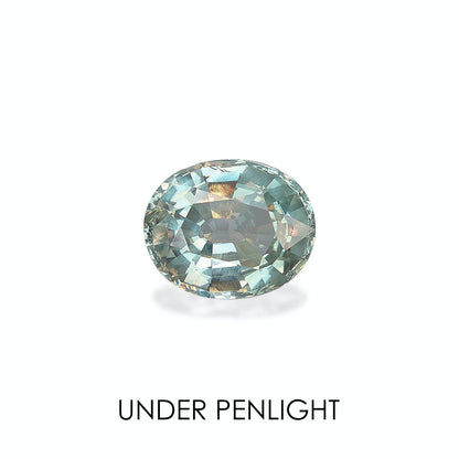 Une alexandrite ovale facettée (2,31 carats) d'une teinte vert-bleu pâle se détache sur un fond blanc, laissant apparaître des reflets sous un projecteur. En dessous, on peut lire « UNDER PENLIGHT » de Bonnot Paris.