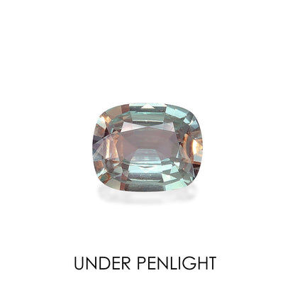 Une alexandrite taille coussin (2,28 carats) de Bonnot Paris, aux teintes bleu clair et pêche, est mise en valeur sur un fond blanc. Les facettes reflètent plusieurs nuances, avec l'inscription « SOUS LA LUMIERE DU STYLO ».