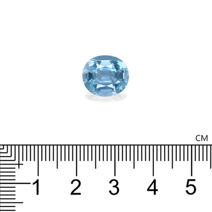 Une exquise Aigue-Marine de 4,57 carats de Bonnot Paris, de taille ovale et aux tons bleus, est présentée au-dessus d'une règle graduée en centimètres pour souligner sa taille. La teinte bleu clair de la pierre facettée se détache sur le fond blanc.