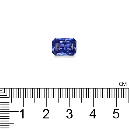 Le Saphir Bleu · 4,13 ct de Bonnot Paris, une pierre précieuse bleue rectangulaire, est sertie sur un fond blanc avec une règle en dessous indiquant sa largeur à environ 1,5 cm.