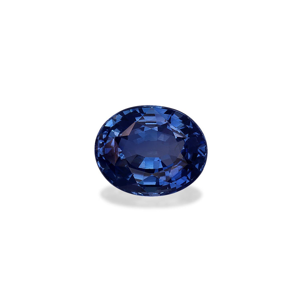 Le Saphir Bleu · 2,04 ct de Bonnot Paris est une pierre précieuse saphir bleu ovale sertie sur un fond blanc uni, ses facettes polies reflétant la lumière, soulignant sa riche teinte bleue.