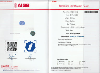Image d'un rapport de pierres précieuses d'AIGS pour le Saphir Bleu de Bonnot Paris. Le saphir, taille coussin, pèse 5,19 carats et le rapport comprend un QR code, une image de la pierre précieuse et les signatures officielles.