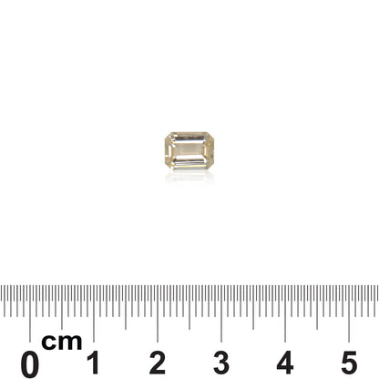 Une petite pierre précieuse rectangulaire transparente, rappelant une taille émeraude, est centrée sur un fond blanc. Sous le Saphir Orange · 1,82 ct de Bonnot Paris se trouve une règle (0–6 cm) servant d'échelle, idéale pour les bijoux sur mesure.
