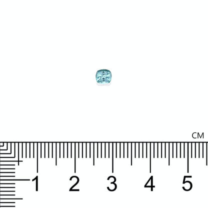 Une petite tourmaline paraïba taille carrée (0,32 ct) de Bonnot Paris, sertie sur un fond blanc et placée au-dessus d'une règle graduée en centimètres. La teinte bleu pâle de la pierre précieuse scintille de mille feux sous la lumière.