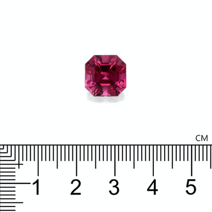 Une petite tourmaline rose octogonale de Bonnot Paris est placée au-dessus d'une règle graduée. Elle semble mesurer environ 0,8 cm de large, présenter une couleur rouge profond et une taille facettée qui reflète magnifiquement la lumière.