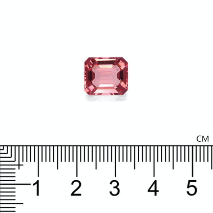 Une tourmaline rose rectangulaire de Bonnot Paris, pesant 6,53 carats et aux bords biseautés, est posée sur une surface blanche. Une règle en dessous indique sa taille : elle mesure un peu plus d'1 cm de large.