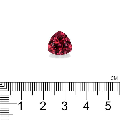 La Tourmaline Rose · 6,31 ct de Bonnot Paris, une petite pierre rouge triangulaire aux facettes réfléchissantes, est placée au-dessus d'une règle. L'échelle graduée en centimètres indique une largeur d'un peu plus d'1 cm.