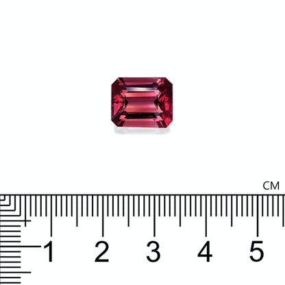 Une tourmaline rose rouge de 5,73 carats, taille émeraude, de Bonnot Paris, est présentée sur fond blanc. Une règle en centimètres sous la pierre précieuse indique sa largeur d'environ 1 cm.