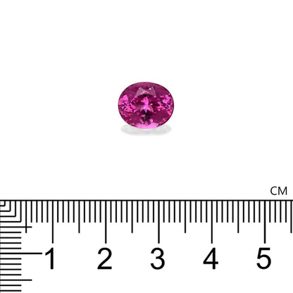 La tourmaline rubellite Bonnot Paris, une pierre rose ovale de 4,35 carats, est placée au-dessus d'une règle graduée en centimètres, mesurant 0,9 cm de diamètre. Sa couleur vive et ses facettes se détachent sur le fond blanc.