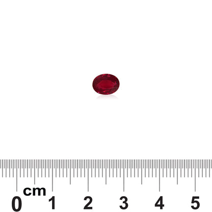 Un Rubis du Mozambique de 1,52 carat de Bonnot Paris, de forme ovale et rouge, est présenté sur une surface blanche avec une règle indiquant que sa taille est d'un peu moins de 1 cm de long.