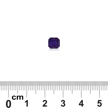 Une petite pierre précieuse Saphir Violet d'un bleu profond de 1,65 carat, signée Bonnot Paris, est posée sur une règle graduée en centimètres et en millimètres. Sa taille octogonale indique qu'elle mesure moins d'un centimètre de diamètre, sur un fond blanc.