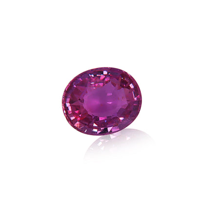 Le Saphir Violet · 1,58 ct de Bonnot Paris est une pierre précieuse de taille ovale, de couleur rose-violet, aux facettes complexes qui reflètent la lumière, présentée sur un fond blanc uni.