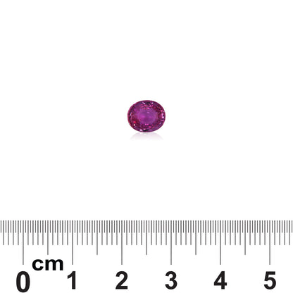 Le Saphir Violet · 1,58 ct de Bonnot Paris, une petite pierre précieuse rose de forme ovale, est présenté au-dessus d'une règle marquée en centimètres et en millimètres pour l'échelle, révélant son diamètre comme inférieur à 1 cm.