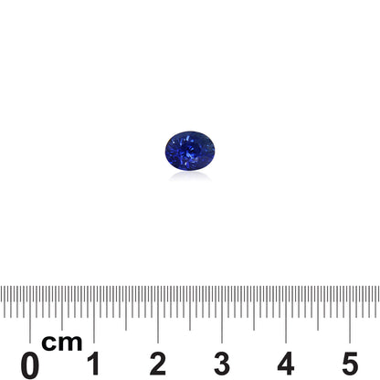 Le Saphir Bleu · 2,12 ct de Bonnot Paris est une petite pierre précieuse bleu foncé ronde et légèrement réfléchissante centrée au-dessus d'une règle métrique affichant des mesures en centimètres sur un fond blanc.