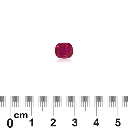 Le Saphir Rose, une pierre précieuse rose vif de Bonnot Paris pesant 3,02 ct, est placé sur une surface blanche à côté d'une règle graduée en centimètres pour comparer la taille.