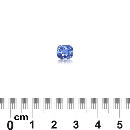 La pierre précieuse Saphir Bleu de 2,02 carats de Bonnot Paris est sertie sur un fond blanc, réfléchissant la lumière à sa base. En dessous, une règle graduée en centimètres de 0 à 5 indique sa taille.