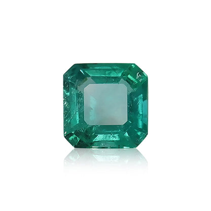 L'Émeraude de Zambie · 1,2 ct de Bonnot Paris est une émeraude taille carrée de couleur verte vive et de facettes réfléchissant la lumière, sertie sur un fond blanc pour souligner sa clarté et sa teinte vibrante.