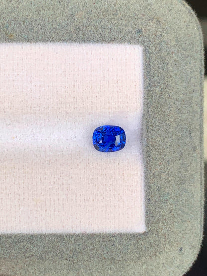 Sur un fond de tissu léger encadré d'une bordure grise texturée, le Saphir Bleu • 1,03ct de [NOUVEAU] Bonnot Paris met en valeur sa taille ovale vive en bleu royal, provenant des célèbres mines du Sri Lanka, incarnant l'essence des véritables pierres précieuses.