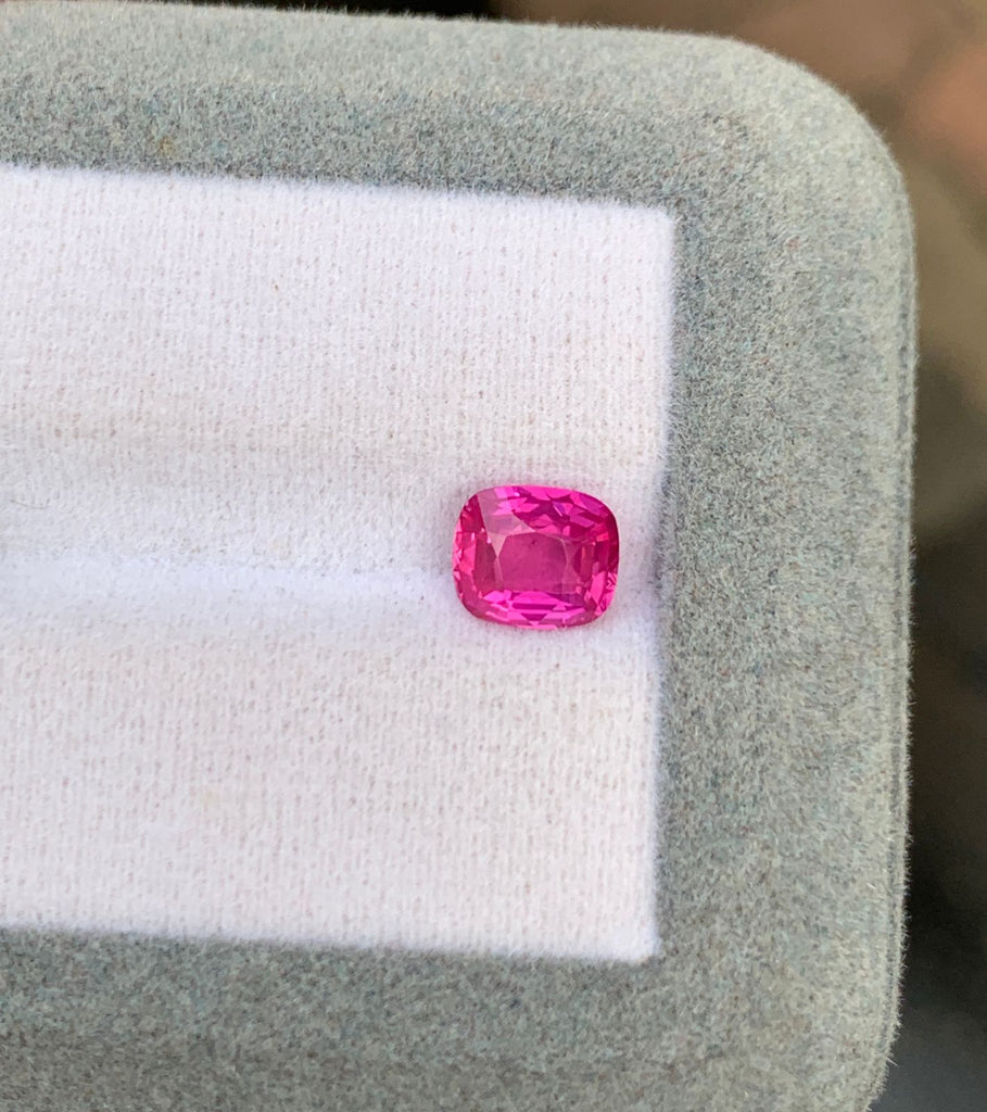 Un saphir rose de 1,52 carat de la collection Bonnot Paris, taillé en forme carrée, scintille sur un fond blanc matelassé bordé d'un liseré gris clair. Originaire du Mozambique, cette gemme naturelle reflète magnifiquement la lumière sur ses facettes exquises.