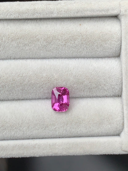 Le Saphir rose Bonnot Paris, une pierre de 2,10 carats aux bords arrondis, est élégamment présenté dans un écrin à bijoux ouvert en velours blanc.