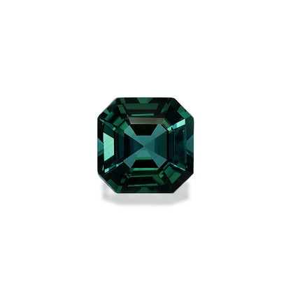 Une tourmaline bleue de 7,99 carats signée Bonnot Paris, taillée en forme rectangulaire brillante aux bords biseautés, se détache sur un fond clair. Ses facettes reflètent la lumière, soulignant sa riche couleur verte.