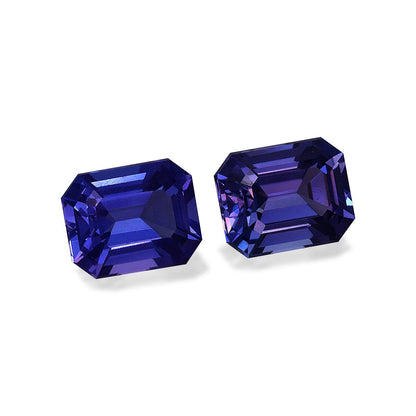 Deux tanzanites taille émeraude de Bonnot Paris, totalisant 6,9 carats, sont placées côte à côte sur un fond blanc uni, mettant en valeur leurs teintes bleu profond et leurs surfaces réfléchissantes.