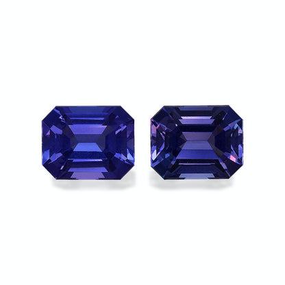 Deux tanzanites Bonnot Paris rectangulaires et facettées (6,9 carats), aux nuances violettes profondes, sont mises en valeur sur un fond uni. Leurs surfaces réfléchissantes mettent en valeur des coupes complexes et des couleurs éclatantes.