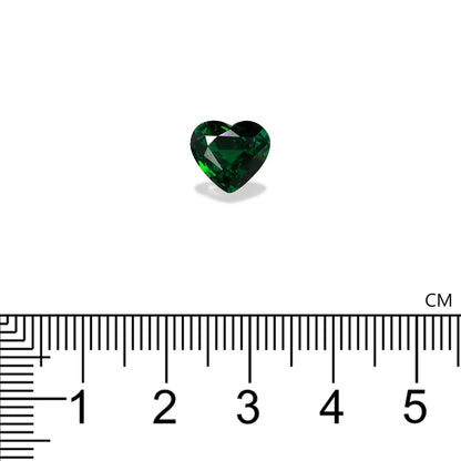La pierre précieuse Grenat Tsavorite en forme de cœur de Bonnot Paris pèse 2,18 carats et est présentée sur un fond blanc à côté d'une règle avec des graduations en centimètres, soulignant sa taille inférieure à 1 centimètre.