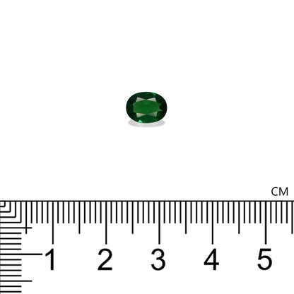 Le Grenat Tsavorite Bonnot Paris, une pierre précieuse verte ovale pesant 0,88 ct, est présenté sur un fond blanc au-dessus d'une règle centimétrique, mesurant environ 0,7 cm de longueur.