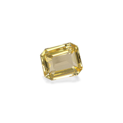 Le Saphir Jaune · 2,05 carats de Bonnot Paris est une pierre précieuse taille émeraude jaune étincelante qui reflète magnifiquement la lumière. Sa forme rectangulaire aux bords biseautés et aux facettes transparentes se détache sur un fond blanc uni.