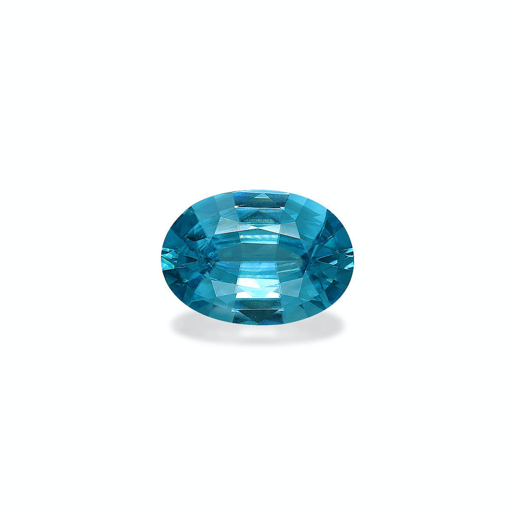 Le Zircon Bleu de 5,79 carats de Bonnot Paris est une pierre précieuse de taille ovale, sertie sur un fond blanc. Sa surface facettée reflète la lumière, soulignant sa teinte bleue vive et sa clarté.