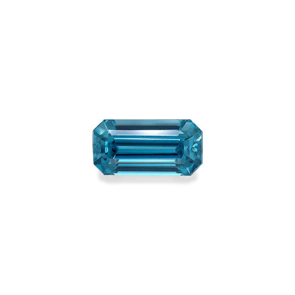 Une pierre précieuse Zircon Bleu rectangulaire allongée facettée de 4,44 ct avec des bords biseautés par Bonnot Paris, reflétant la lumière sur un fond blanc uni.