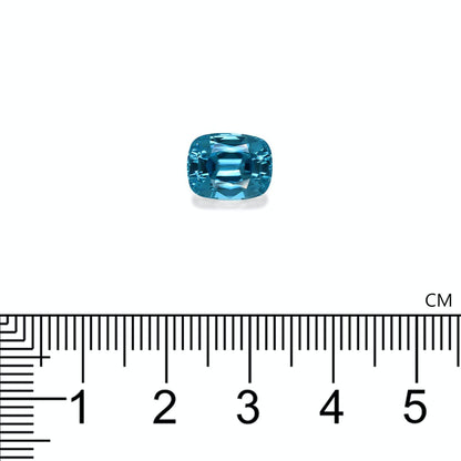 Une petite pierre précieuse bleue rectangulaire nommée Zircon Bleu · 5,29ct de Bonnot Paris aux bords arrondis est présentée au-dessus d'une règle graduée en centimètres, mesurant environ 1,2 cm.